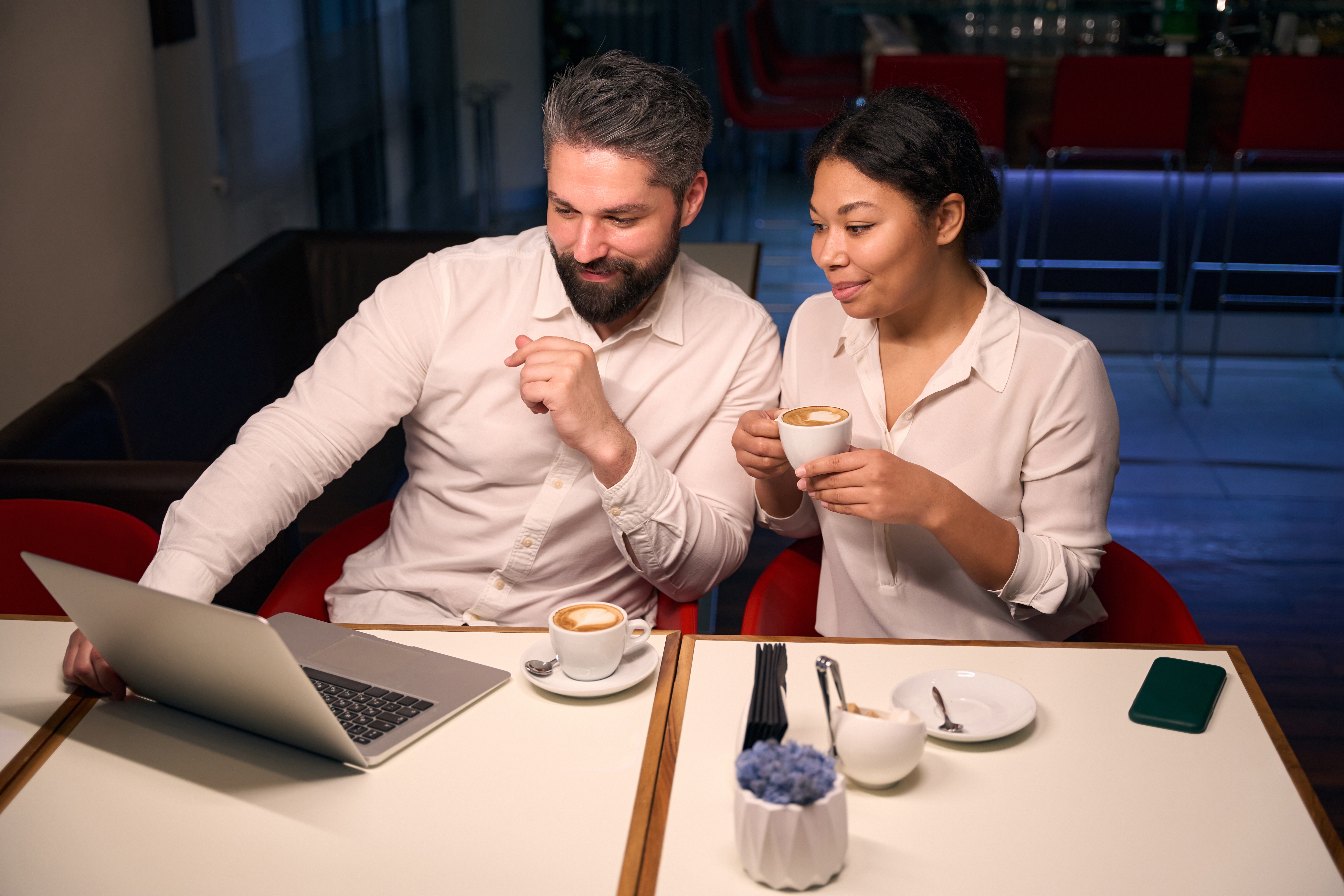 young couple drinking coffee looking at computer